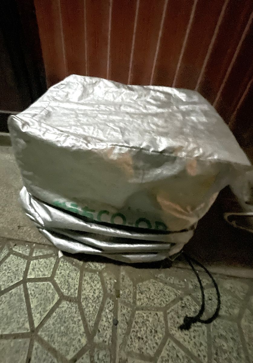 玄関前に置かれた、銀色のカバーがかかったおうちコープの箱